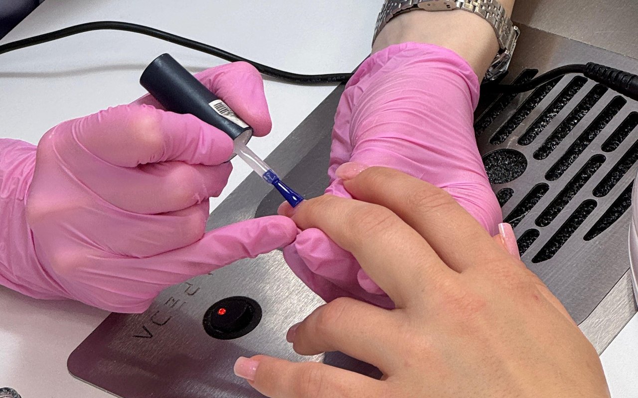 Een manicure aan de nageltafel