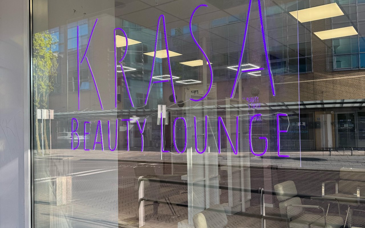 De etalageruit met KRASA Beauty Lounge in paarse letters